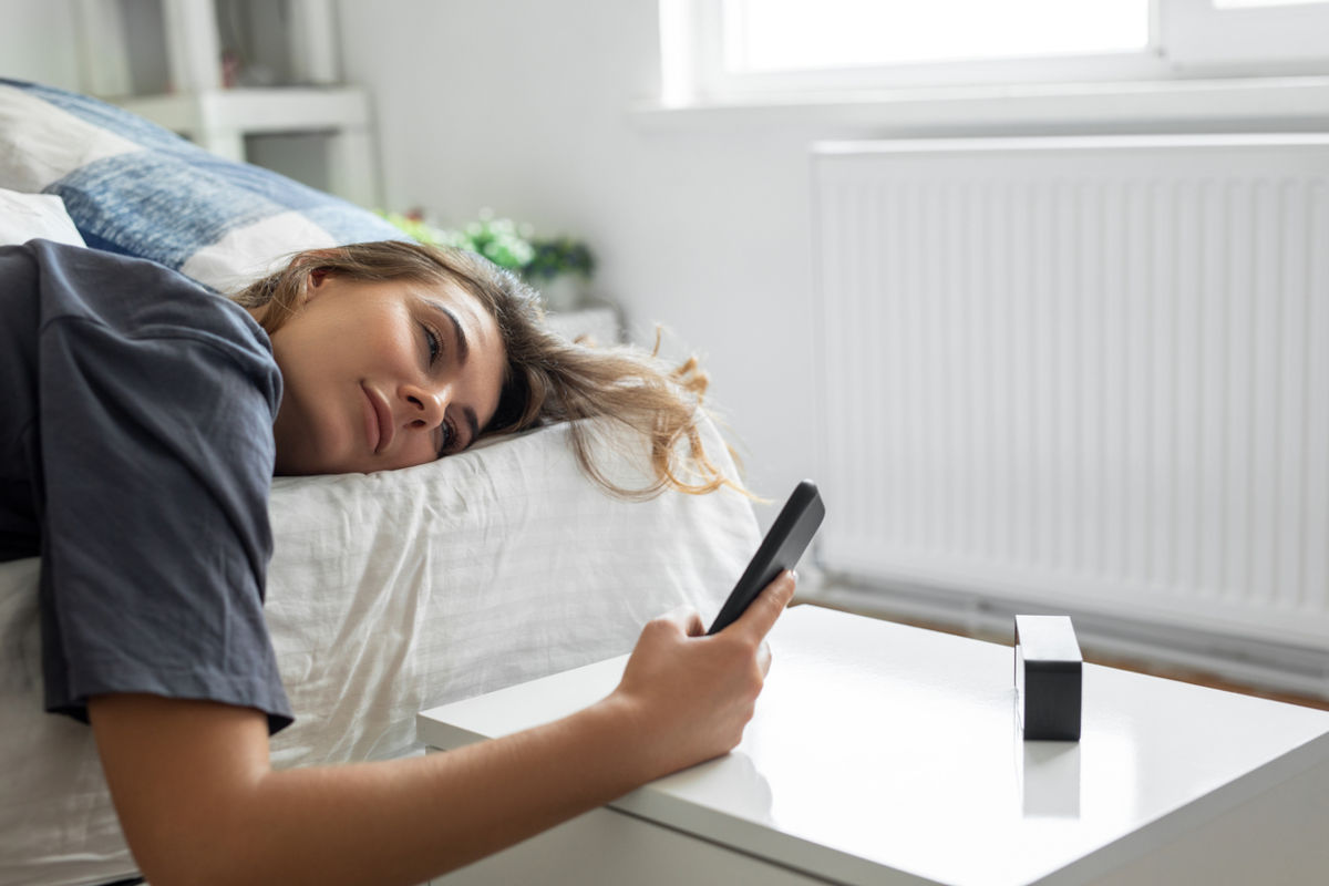 Woman napping and setting alarm on phone