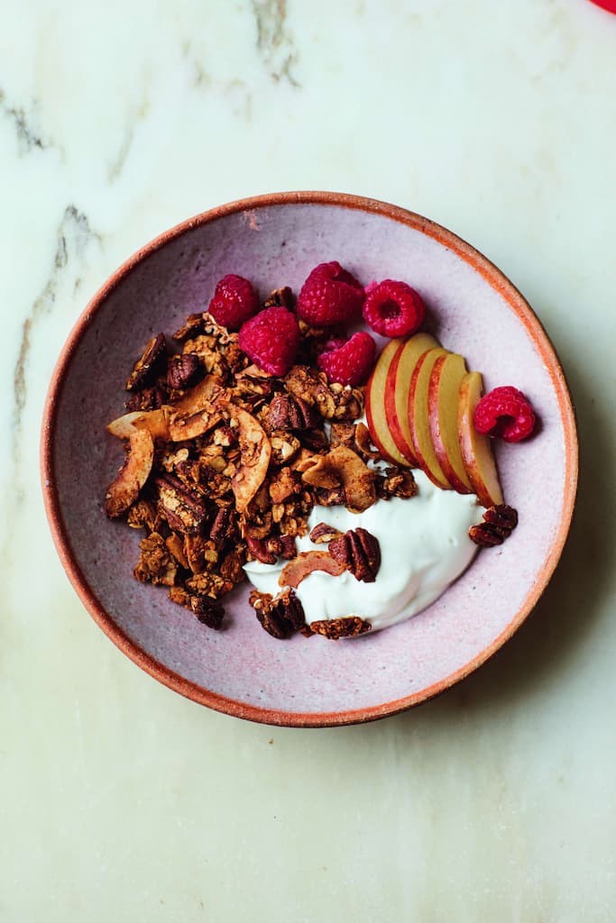 Pecan and coconut granola in a bowl with yoghurt and fruit