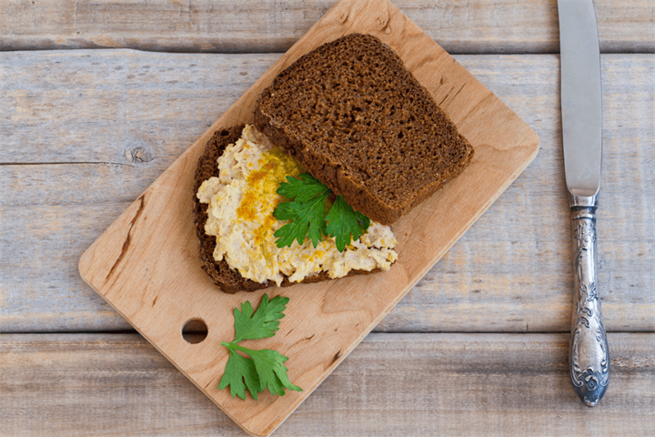 Mashed chickpeas with tahini on sliced dark rye bread