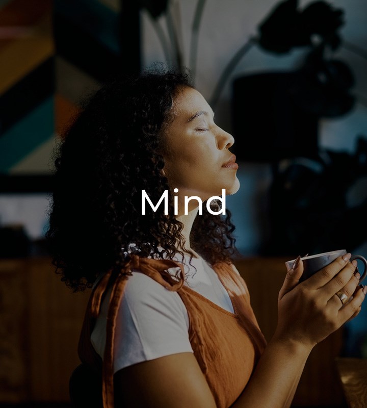 Woman holding cup with eyes closed looking peaceful