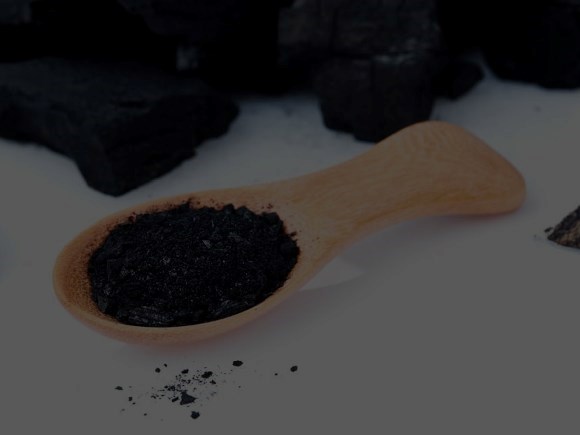 Charcoal bricks and a wooden spoon of charcoal