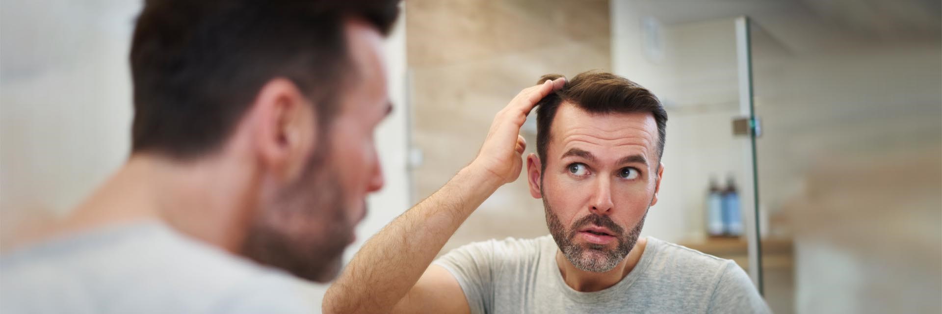 Man checking hair in mirror