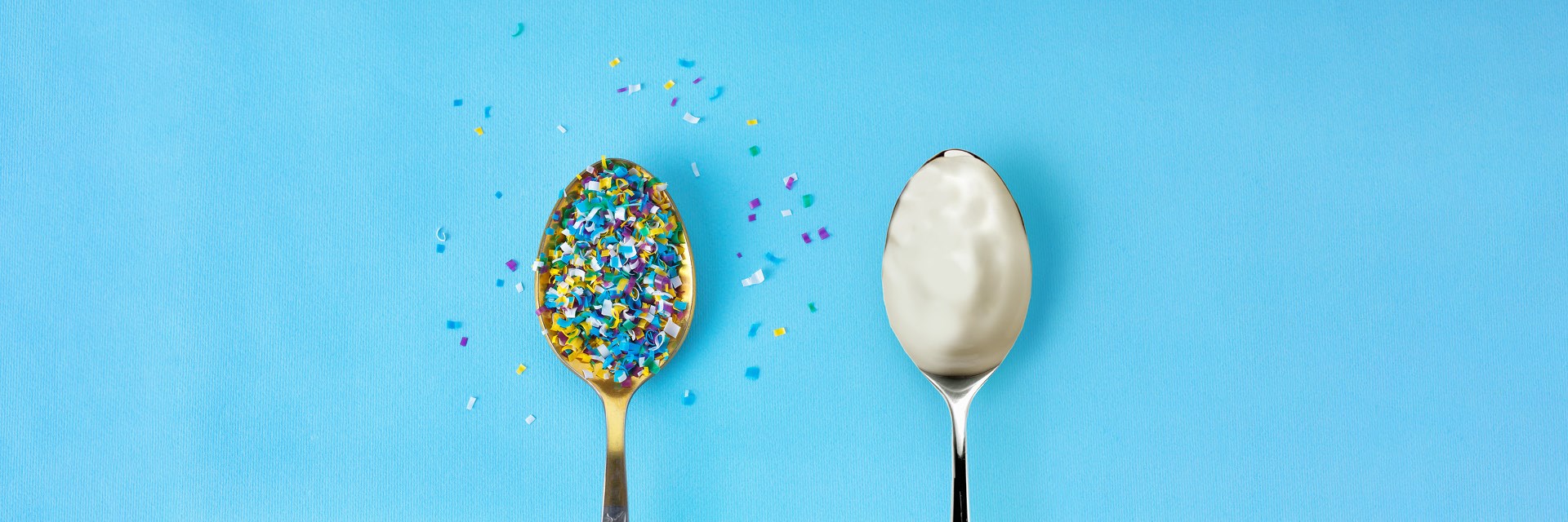 Spoon with coloured paper and spoon with yoghurt