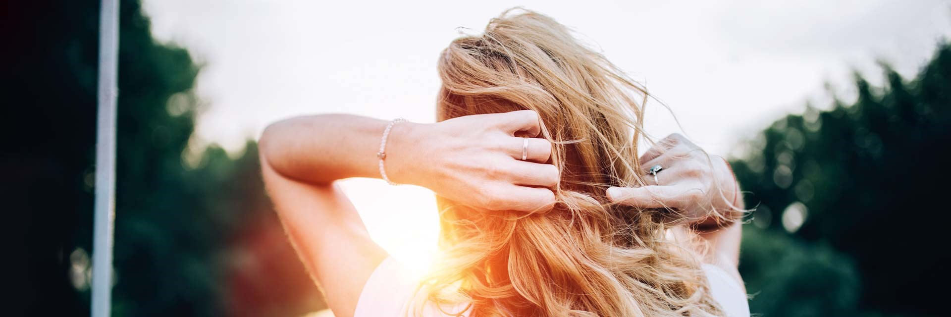 Woman with fingers in hair in evening sunshine