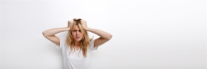 A distressed-looking woman holding her hair