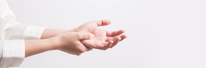 Person holding one hand in pain