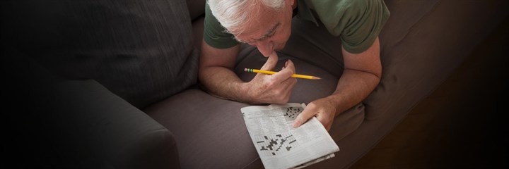 Man lying down doing a crossword
