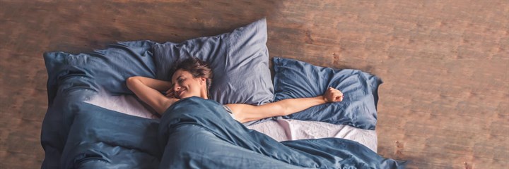 Woman in bed stretching
