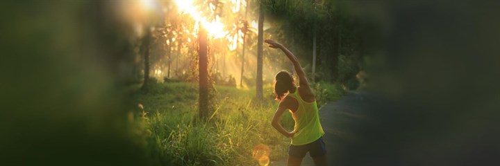 Woman in woodlands stretching