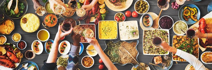 Overhead view of table with lots of food and people eating