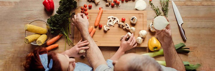 A couple cooking vegetables