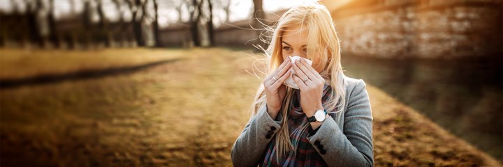 Image of a woman blowing her nose