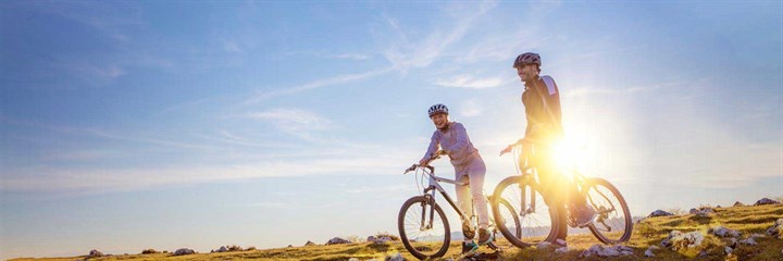 Two people cycling in the sun