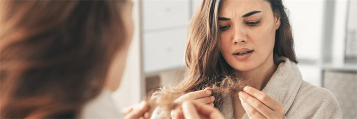 A woman struggling to brush her hair