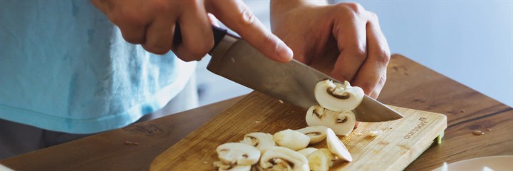 Chopping up mushrooms on chopping board