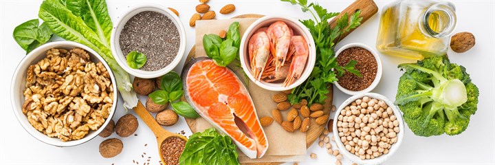 An overhead photo of food containing omega 3, salmon, prawns, walnuts, flax seeds, broccoli
