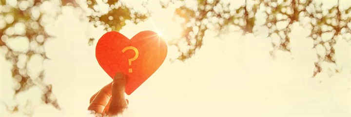 Heart-shaped paper with question mark in the sunshine