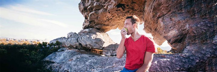 Athlete sitting outside eating an apple