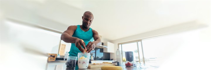 Muscular man making a smoothie