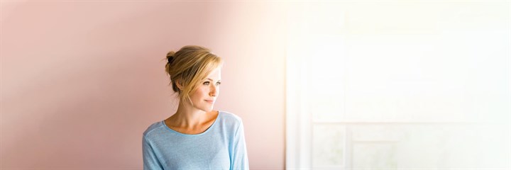 Woman with blonde hair next to sunny window