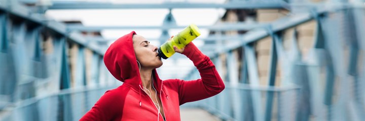 A sportswoman drinking from a bottle