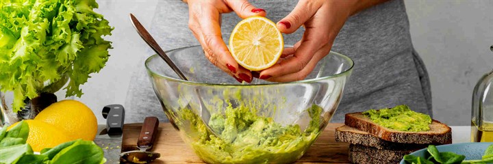 Person squeezing orange into salad