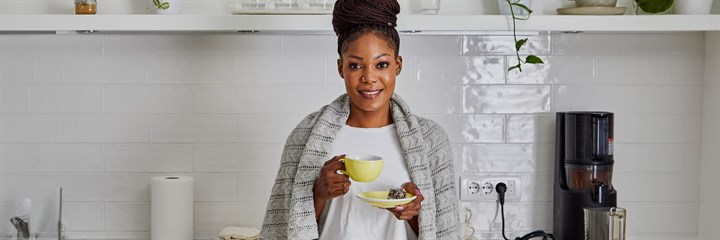 Healthy and happy woman having coffee in her kitchen