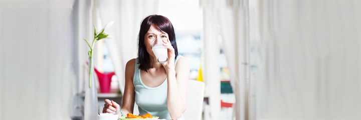 Woman eating fruit and drinking milk