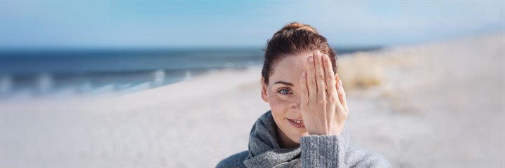 Woman with her hand over one eye