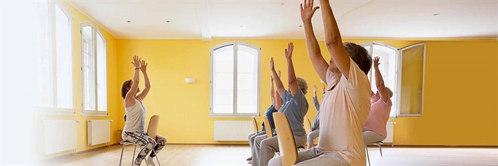 People on chairs in a yoga class