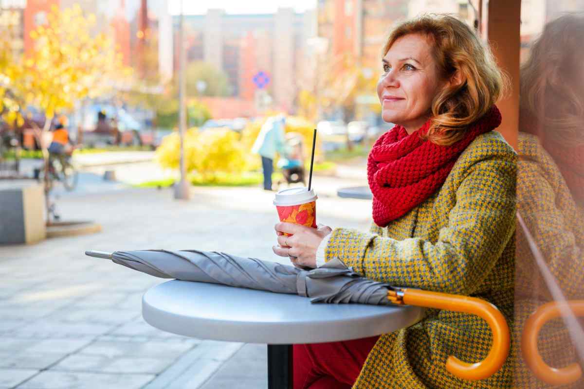 Woman with curly hair sitting outside cafe