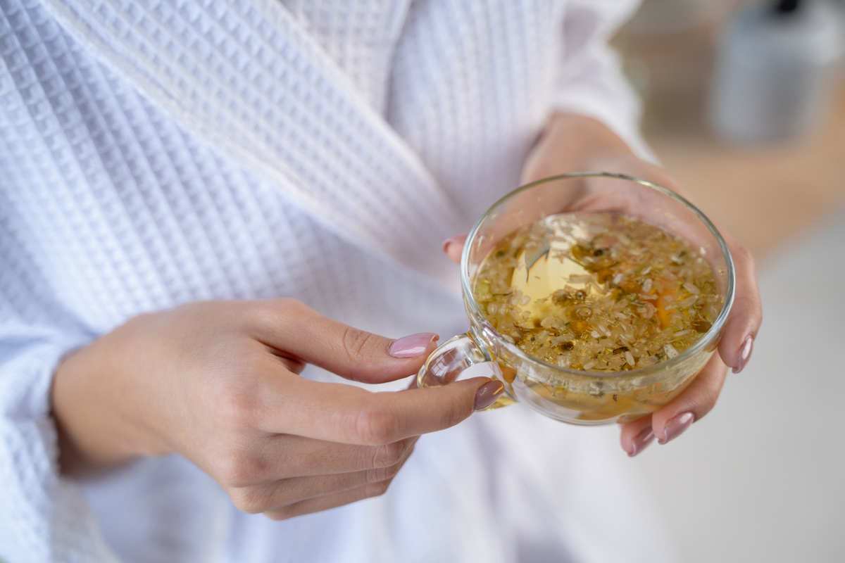 Woman holding cup of chamomile tea