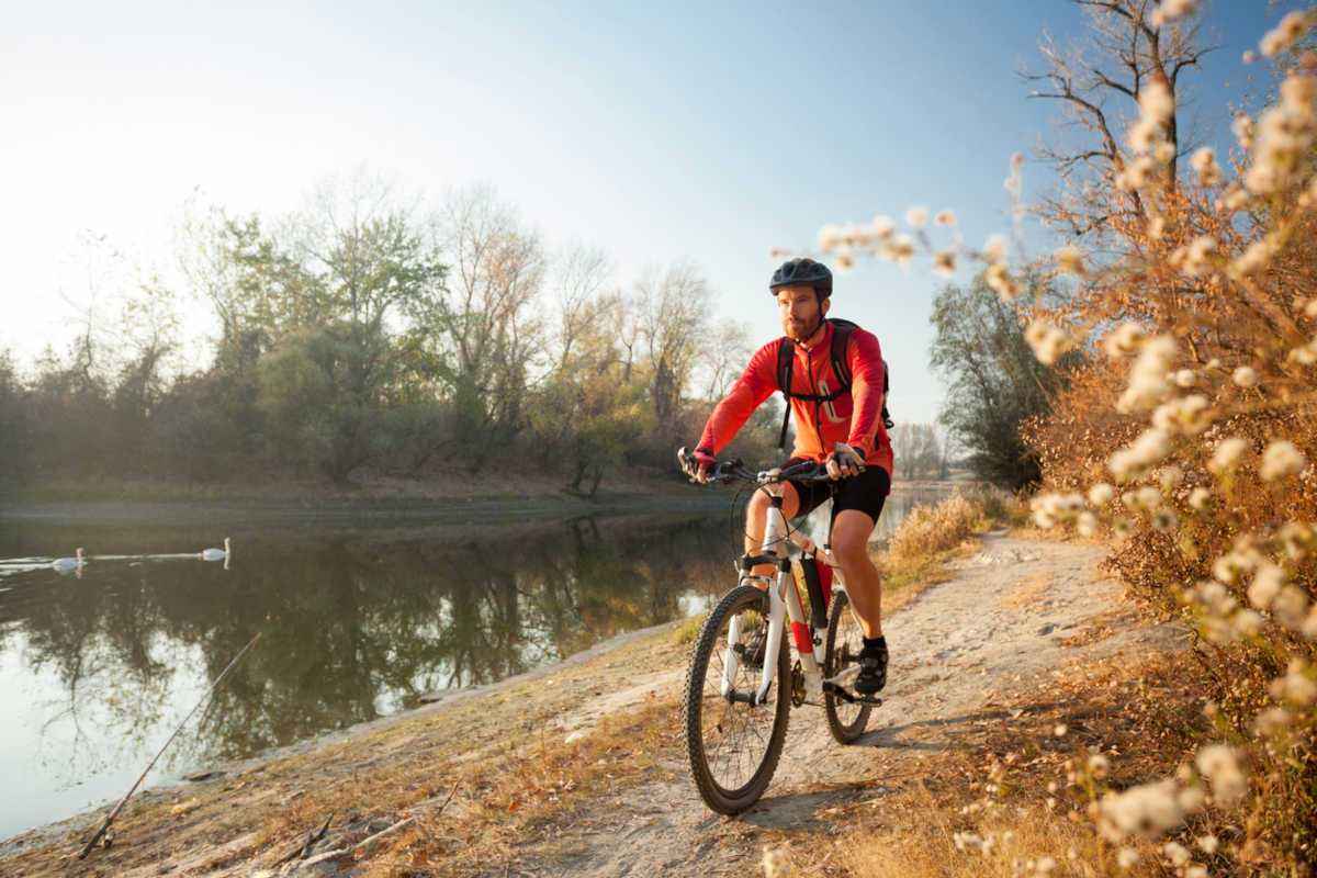 Man riding bike next to lake
