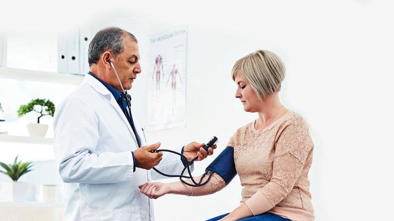 Doctor testing patient's blood pressure