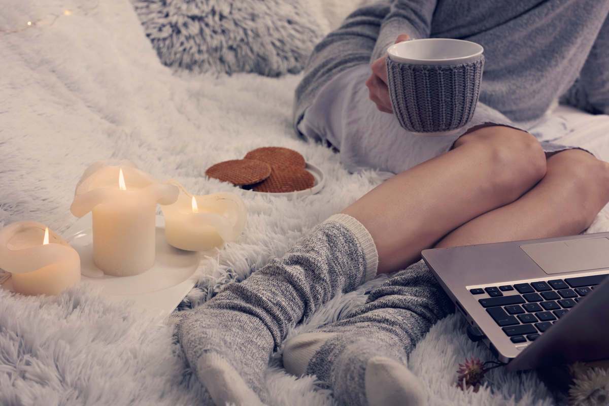 Cosy hygge scene with candles and hot drink