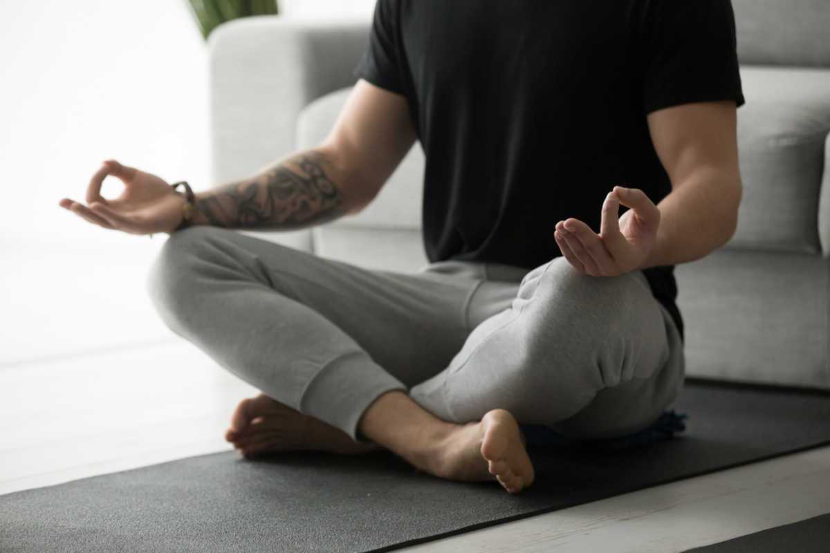 Man meditating on yoga mat