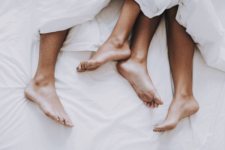 Man and woman's feet in bed