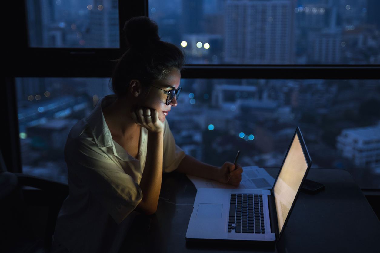 Woman working on laptop late at night