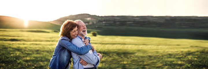 Image of a couple in the countryside cuddling and laughing