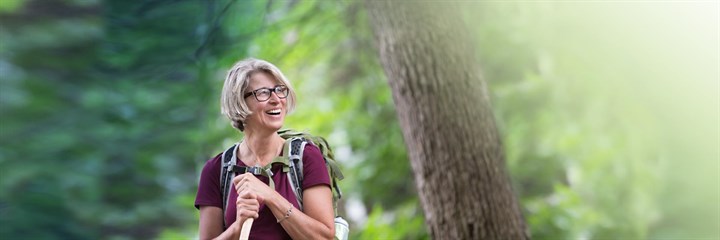 Image of a woman smiling whilst on a hike