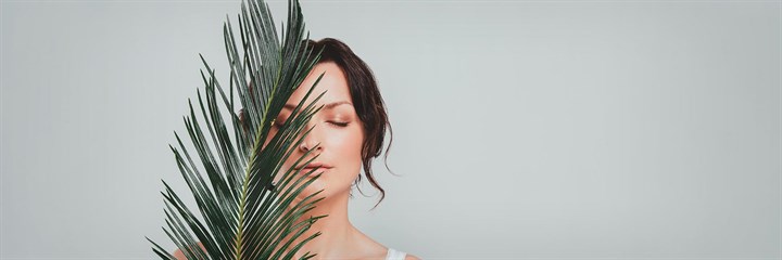 Woman with a leaf covering half of her face