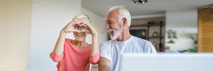 Image of an older couple with woman making heart symbol