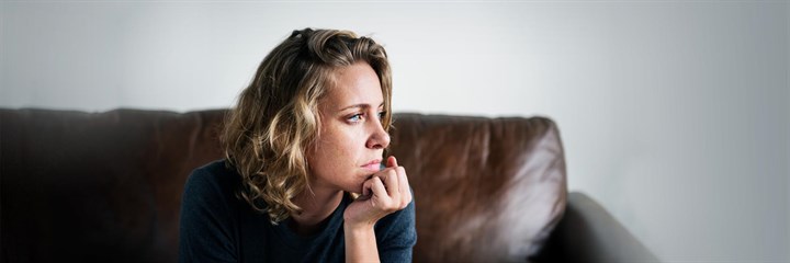 A woman looking unhappy on a sofa