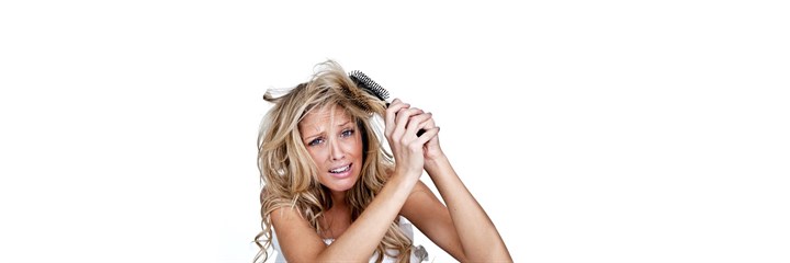 A woman struggling to brush her hair